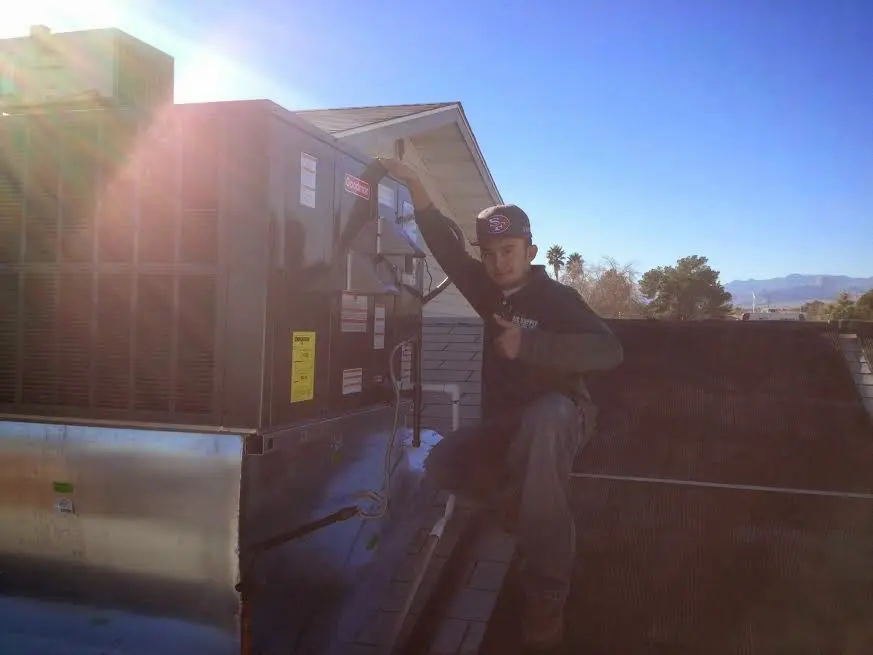 HVAC technician performing AC Tune-Up on a rooftop unit in Metuchen